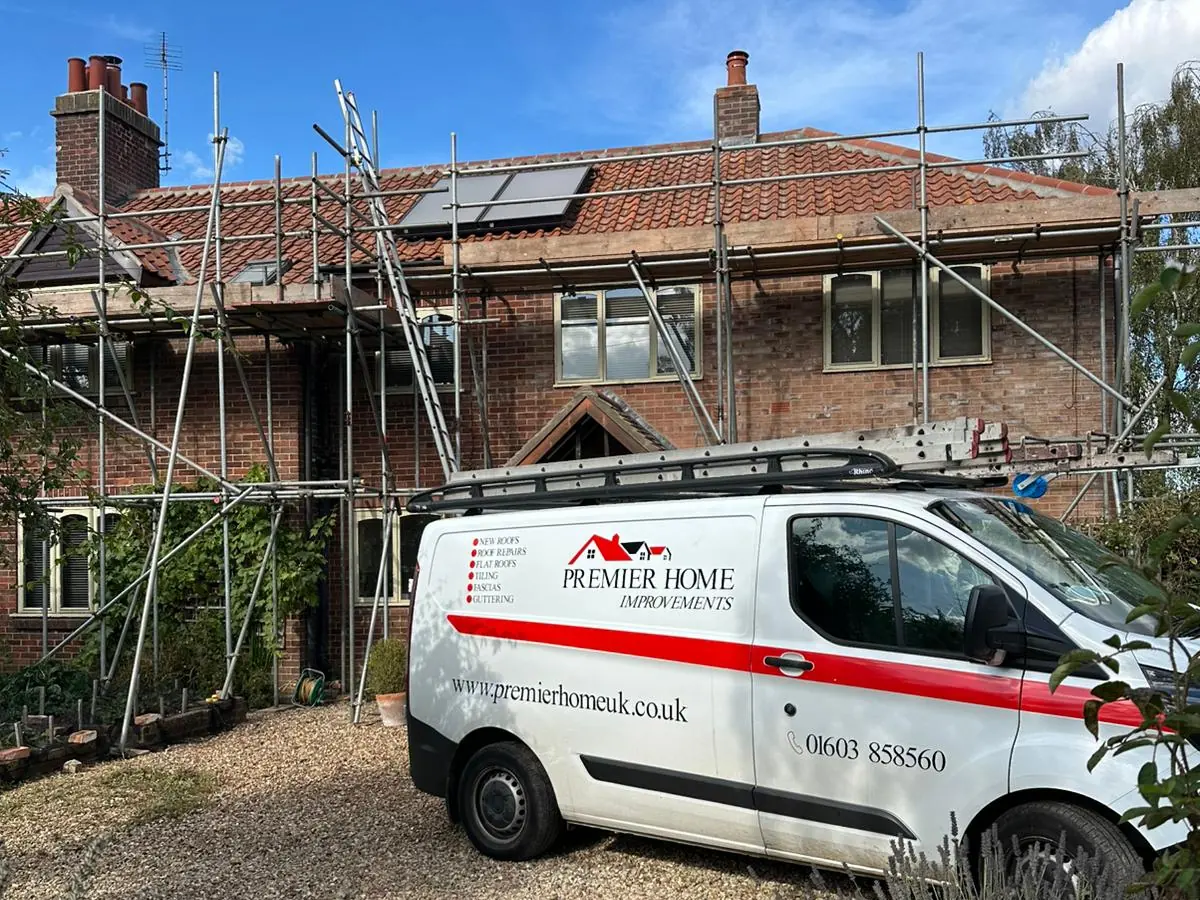 Premier Home Improvements sign-written van outside a re-roof in progress in Norwich