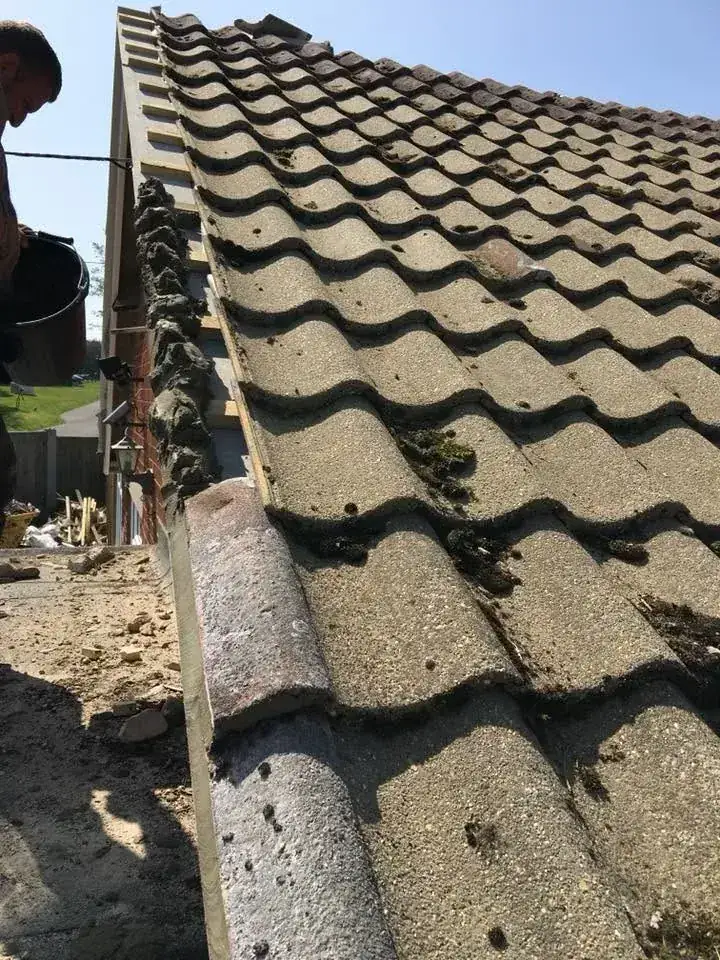 Old moss covered tiles stripped from a roof and stacked in Norwich