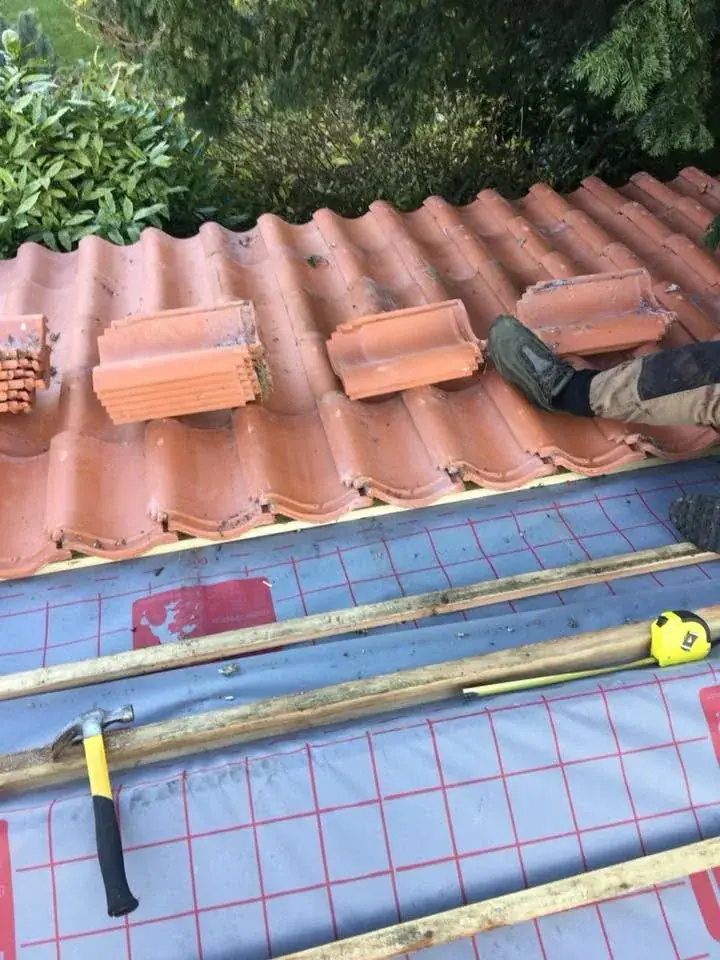 Red pantiles being laid over new battens and breathable membrane in Norwich