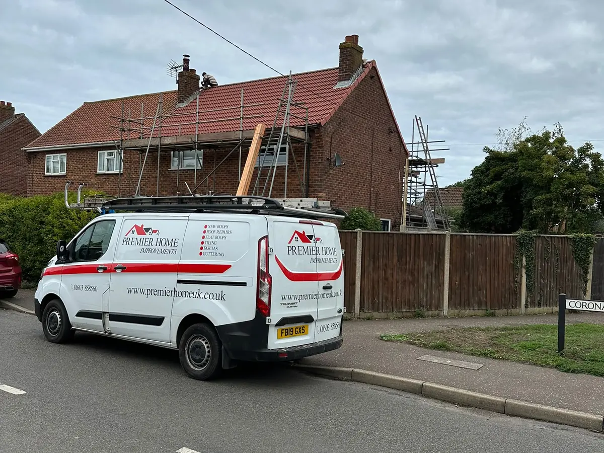 Premier Home Improvements roofer on the ridge of a new tiled roof in Norwich