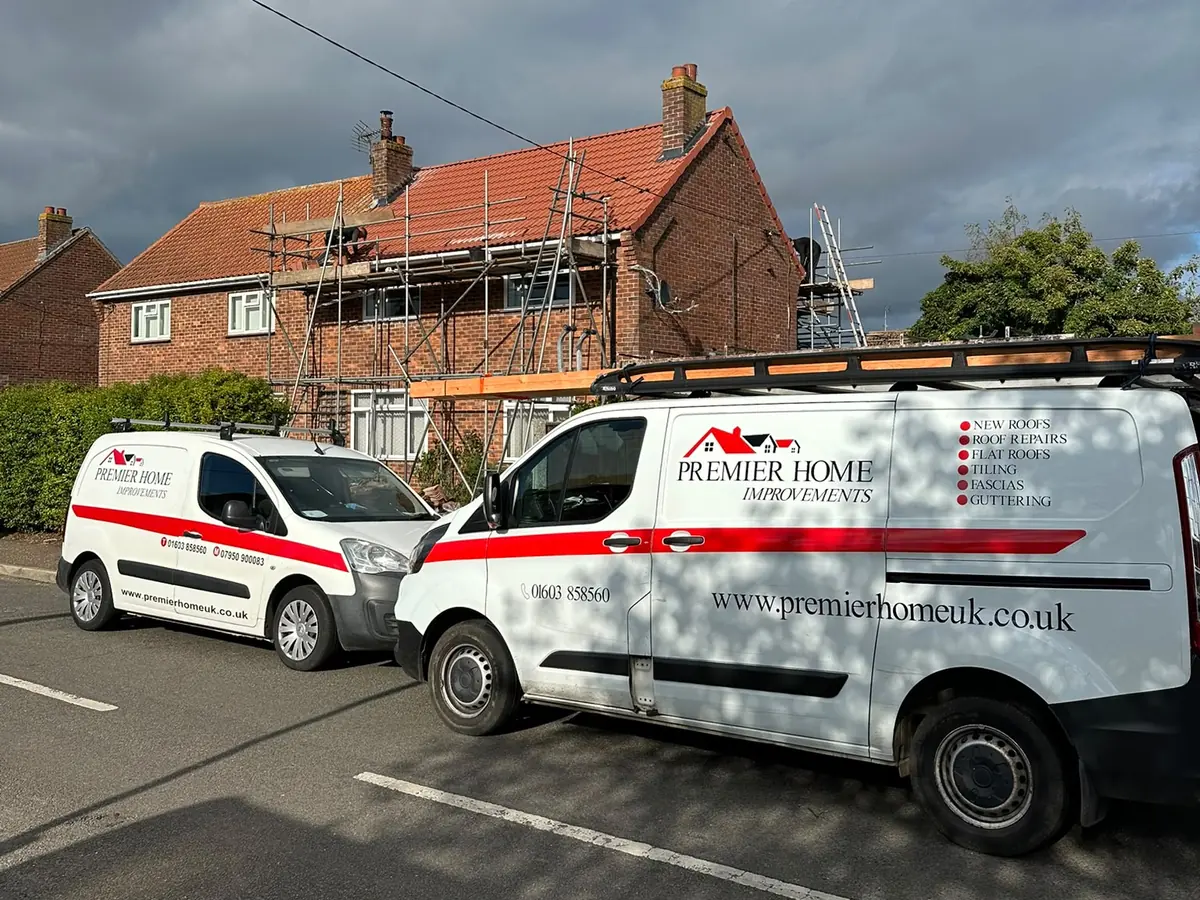 Two Premier Home Improvements vans parked outside a re-roof in Norwich