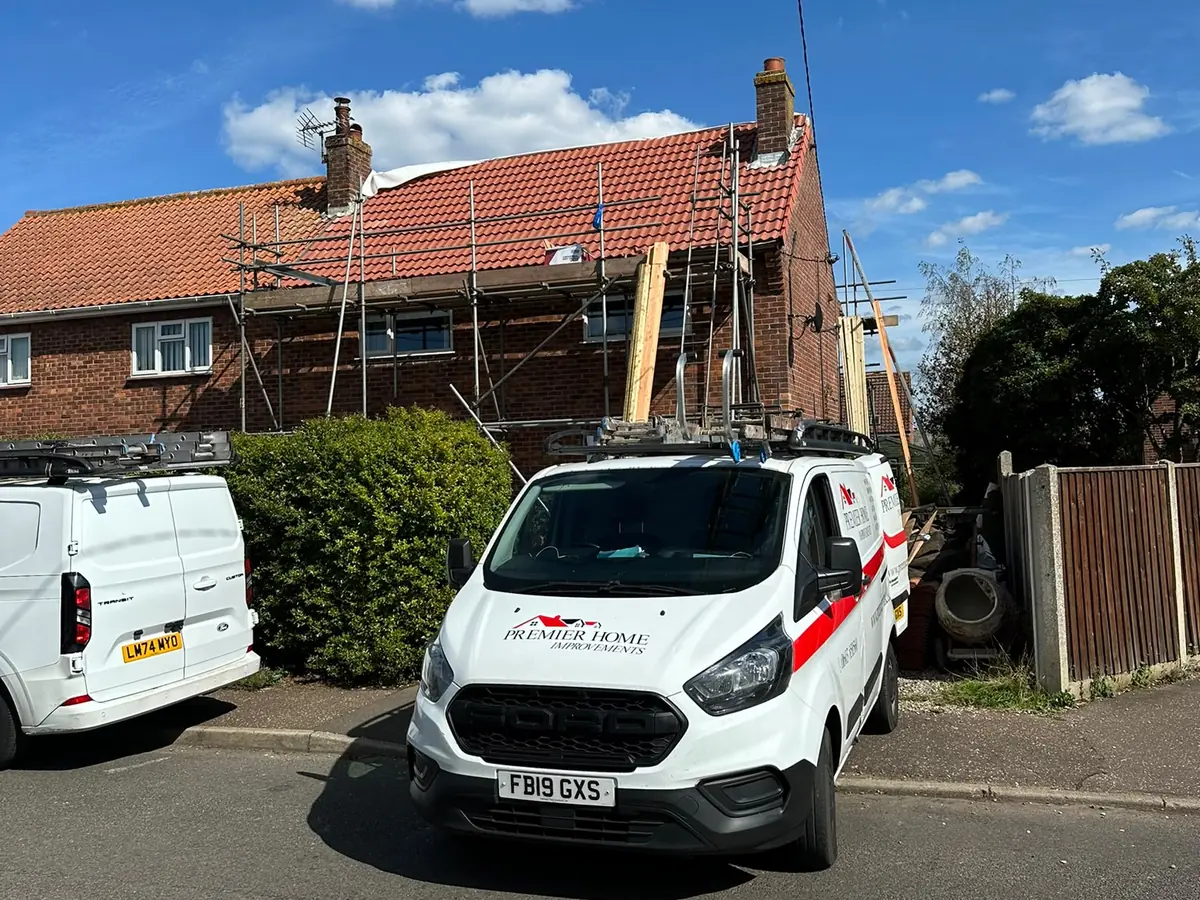 Premier Home Improvements van in front of a newly tiled roof in Norwich