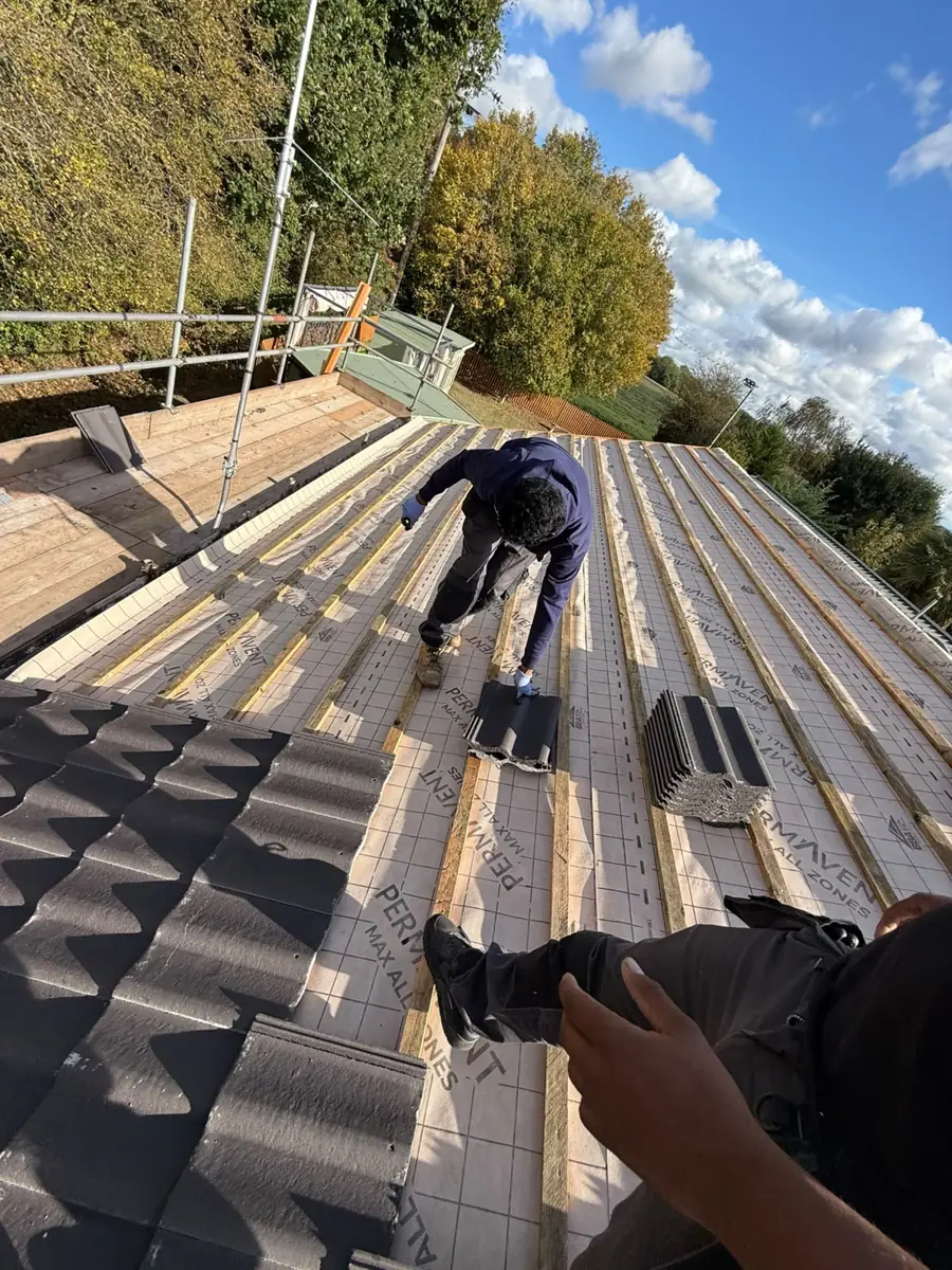 Roofer fixing new battens over breathable membrane on a Diss bungalow
