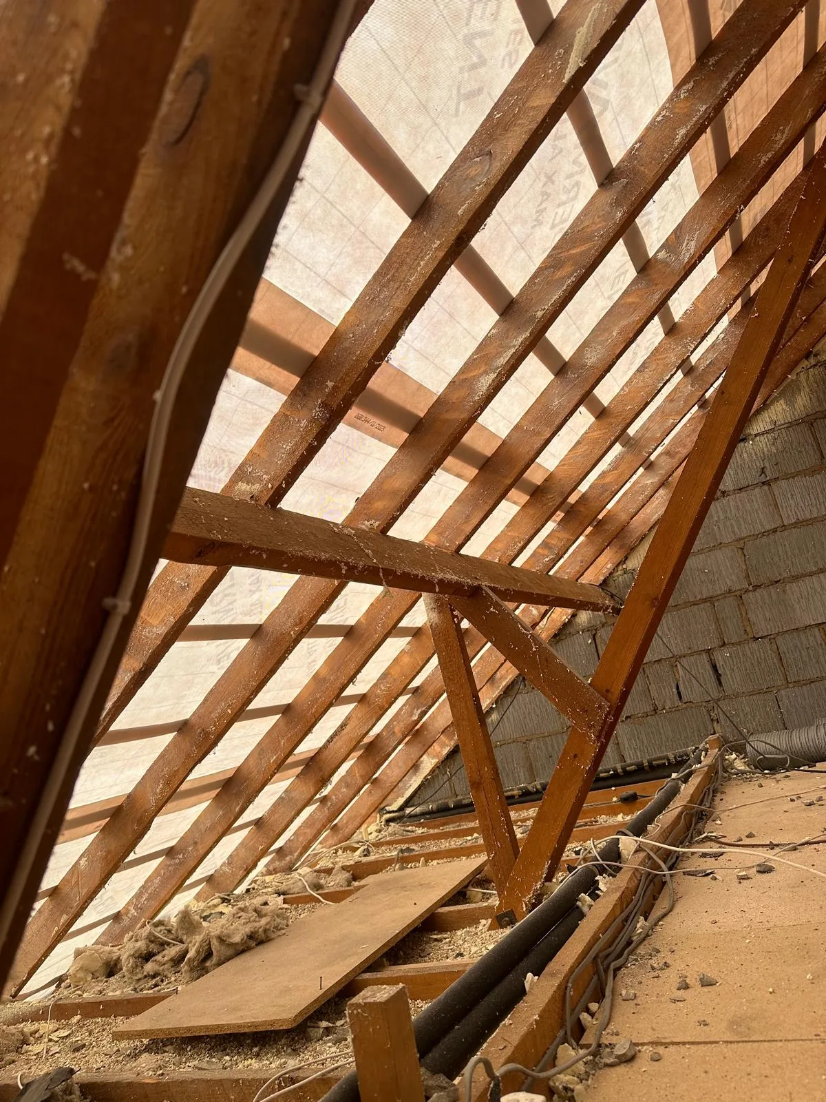 Bare rafters and blockwork gable with the roof covering removed