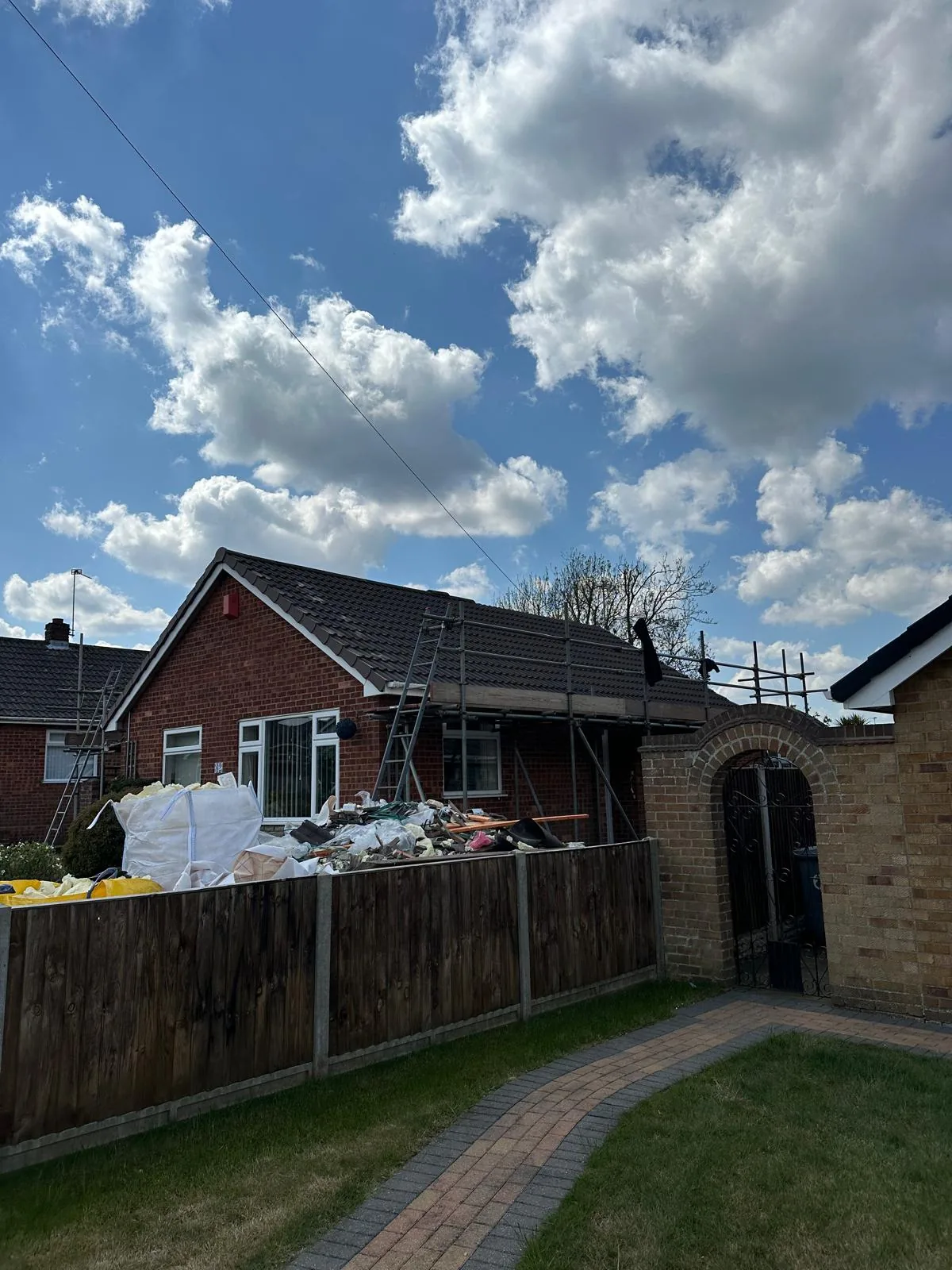 Bulk bags of removed spray foam and roof waste in a front garden